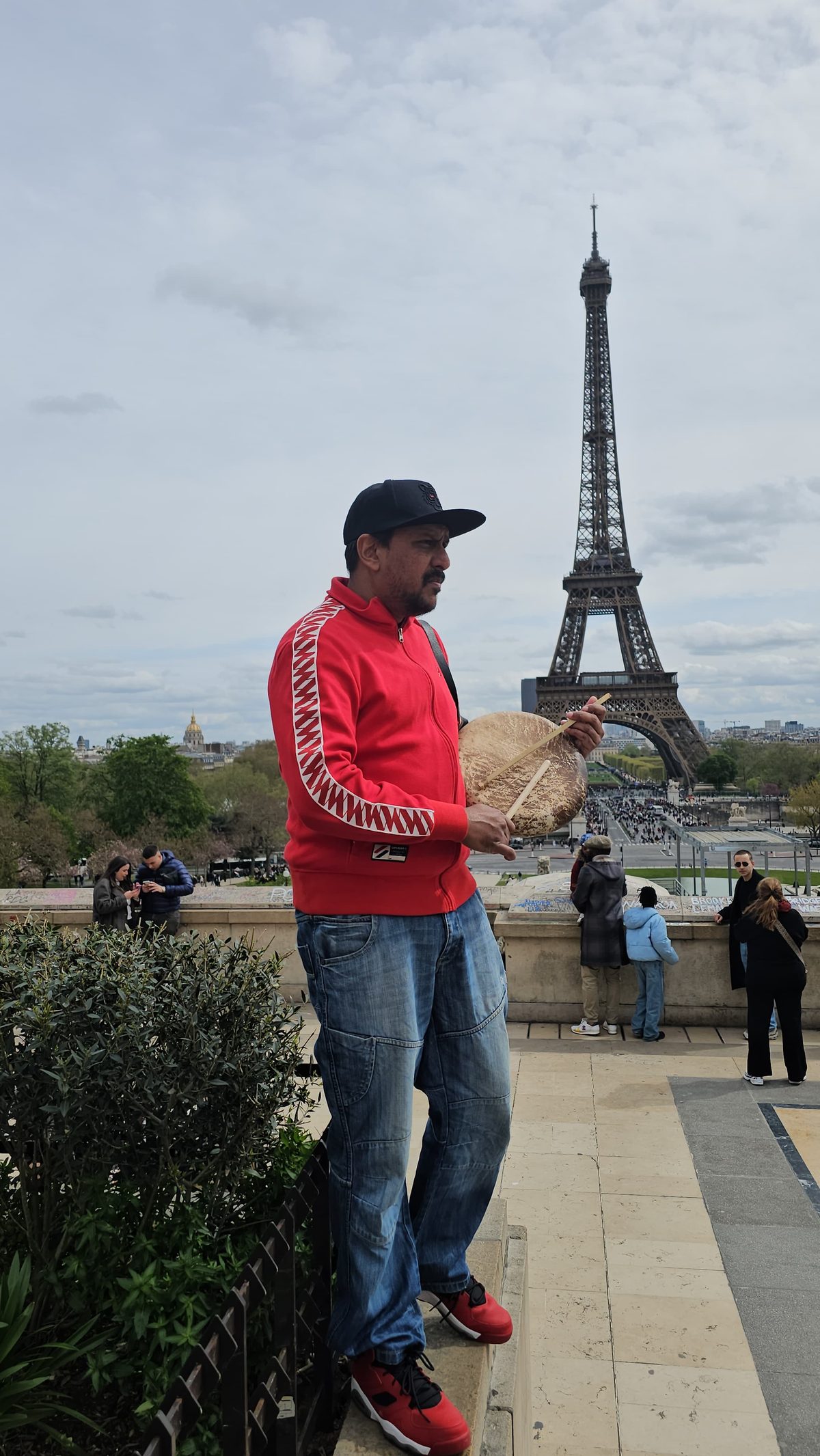 A Tamil Arts UK drummer playing the parai in front of the Eiffel Tower in Paris