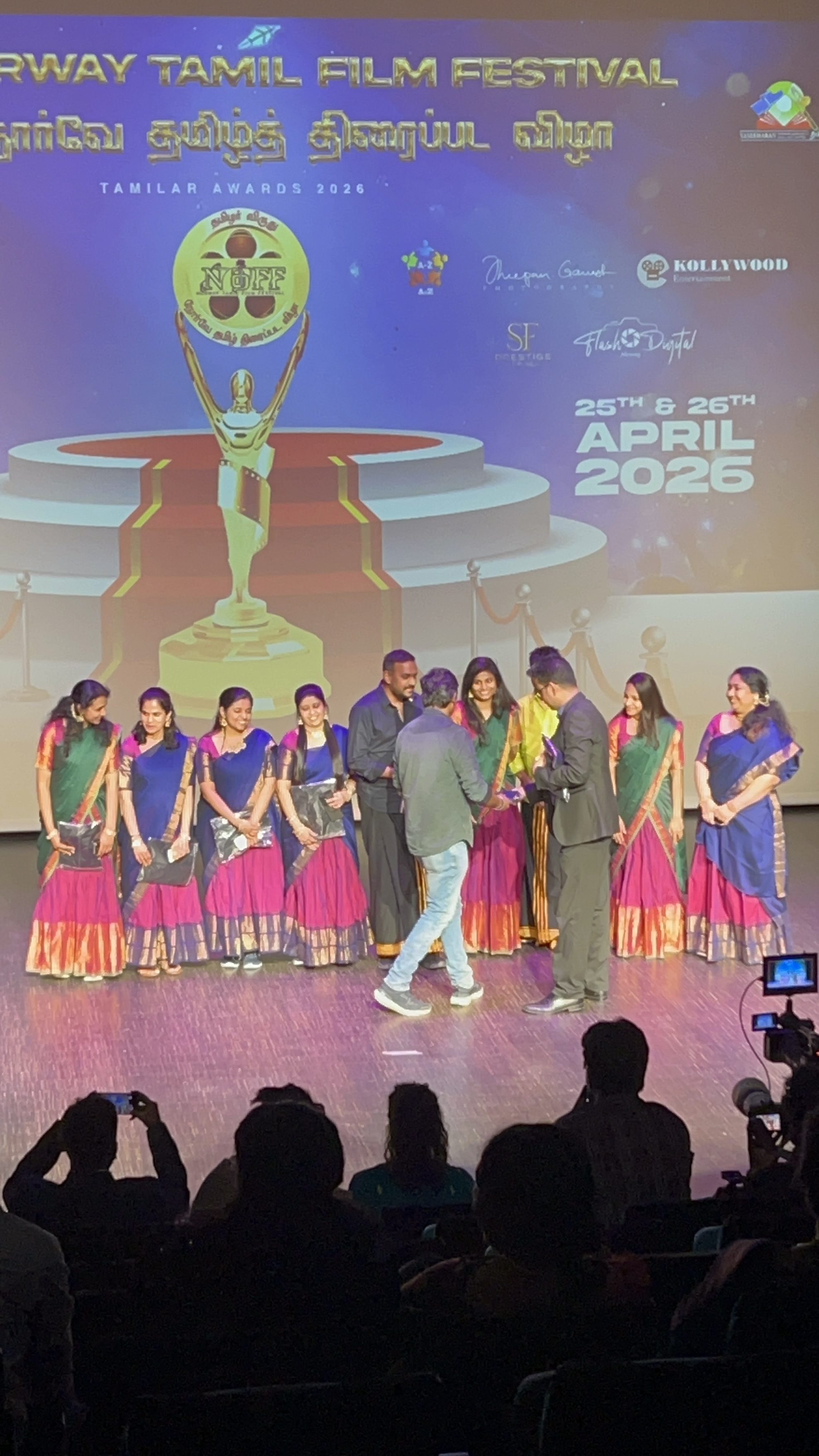 The troupe lined up on stage at the Tamilar Awards in front of the awards backdrop