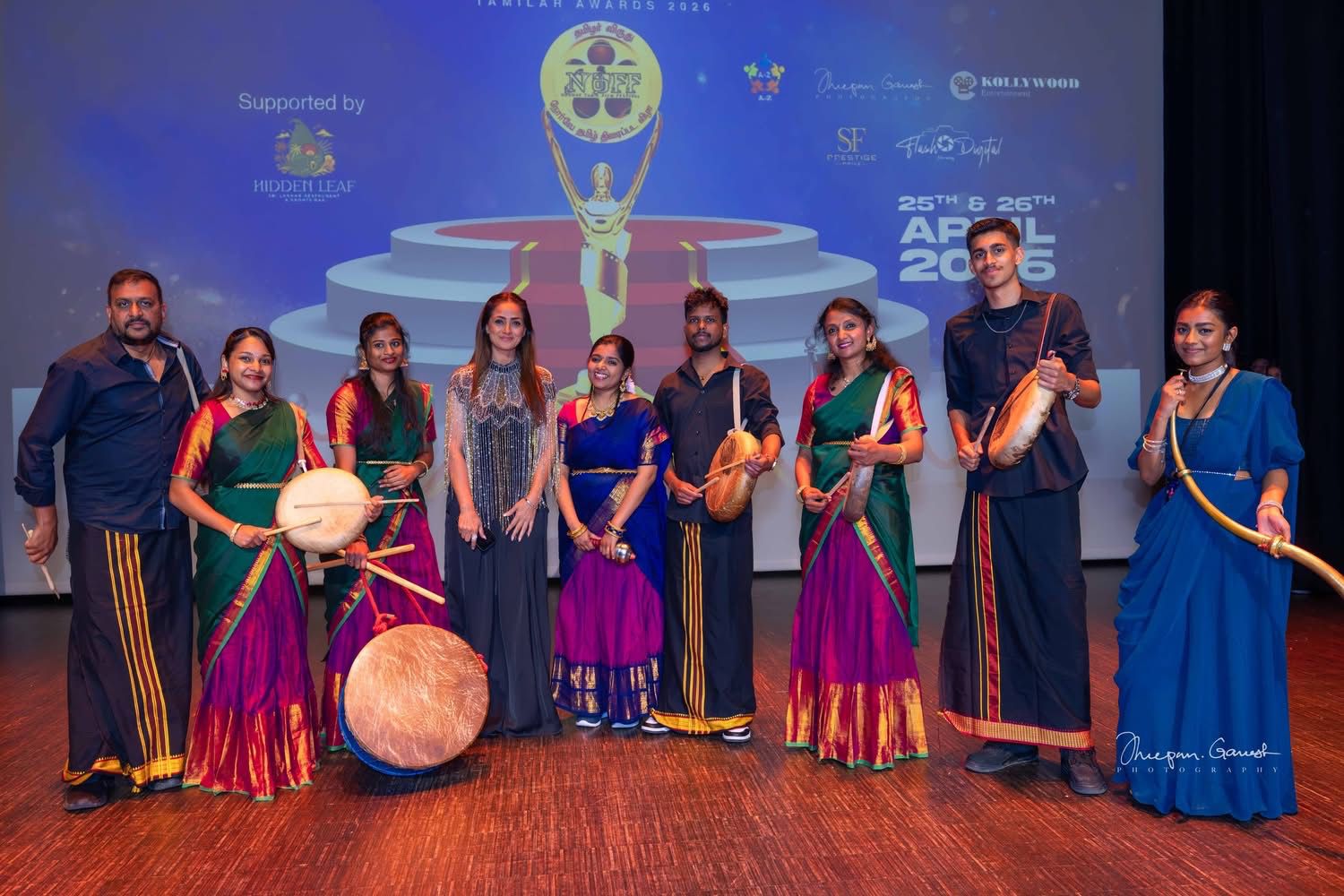 The troupe on stage at the Tamilar Awards in Norway, in front of a lit awards backdrop