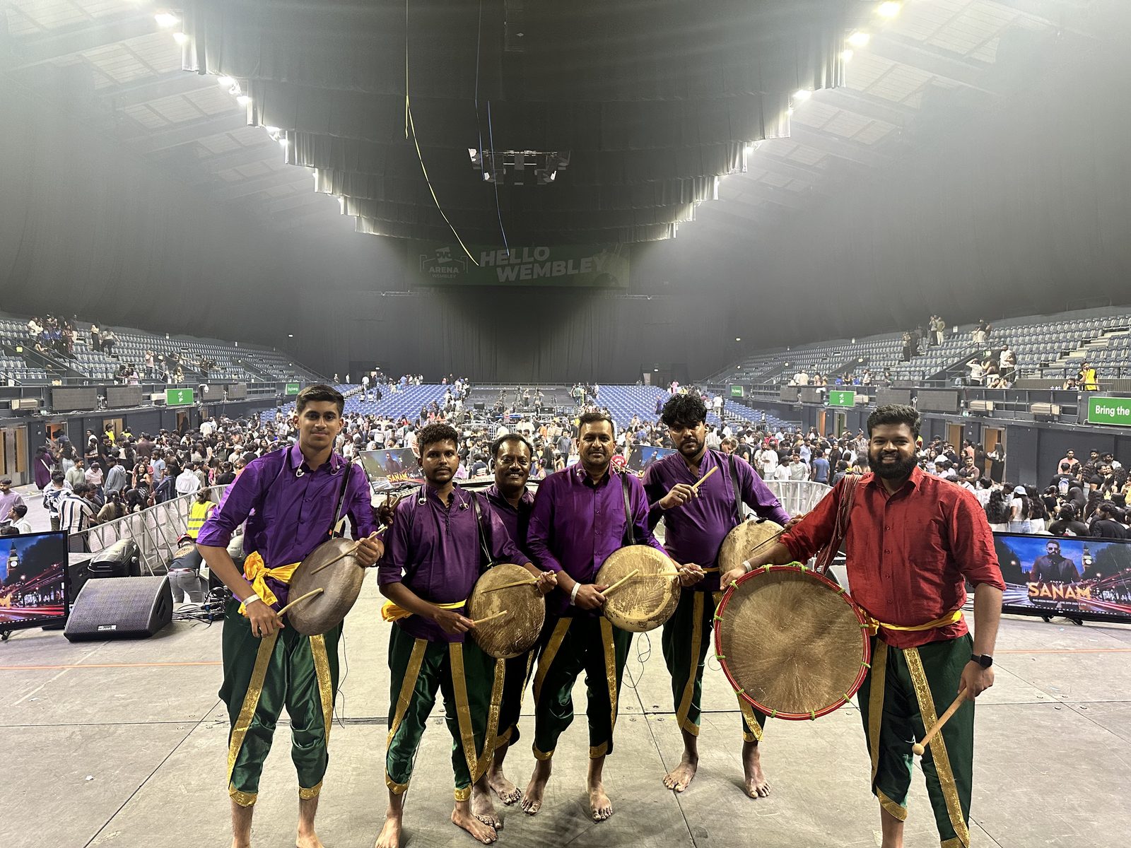 Six parai players in purple and green standing on the arena floor at Wembley, a HELLO WEMBLEY banner behind them